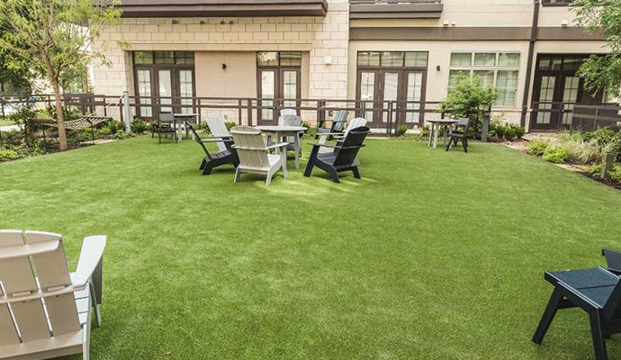 Modern apartment complex courtyard Courtyard with artificial turf and outdoor seating.