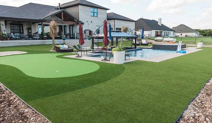 Backyard resort with artificial turf Luxury backyard with a pool and an artificial turf putting green.