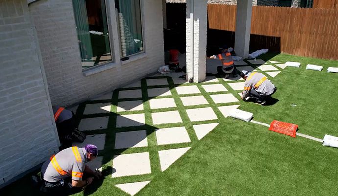 Synthetic grass installation in residential area Expert team installing synthetic grass in residential area