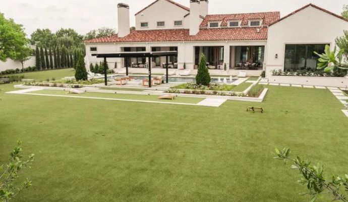 Luxury backyard pool area at residential home with artificial grass