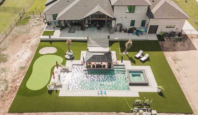 Installed synthetic grass around pool area in front of home
